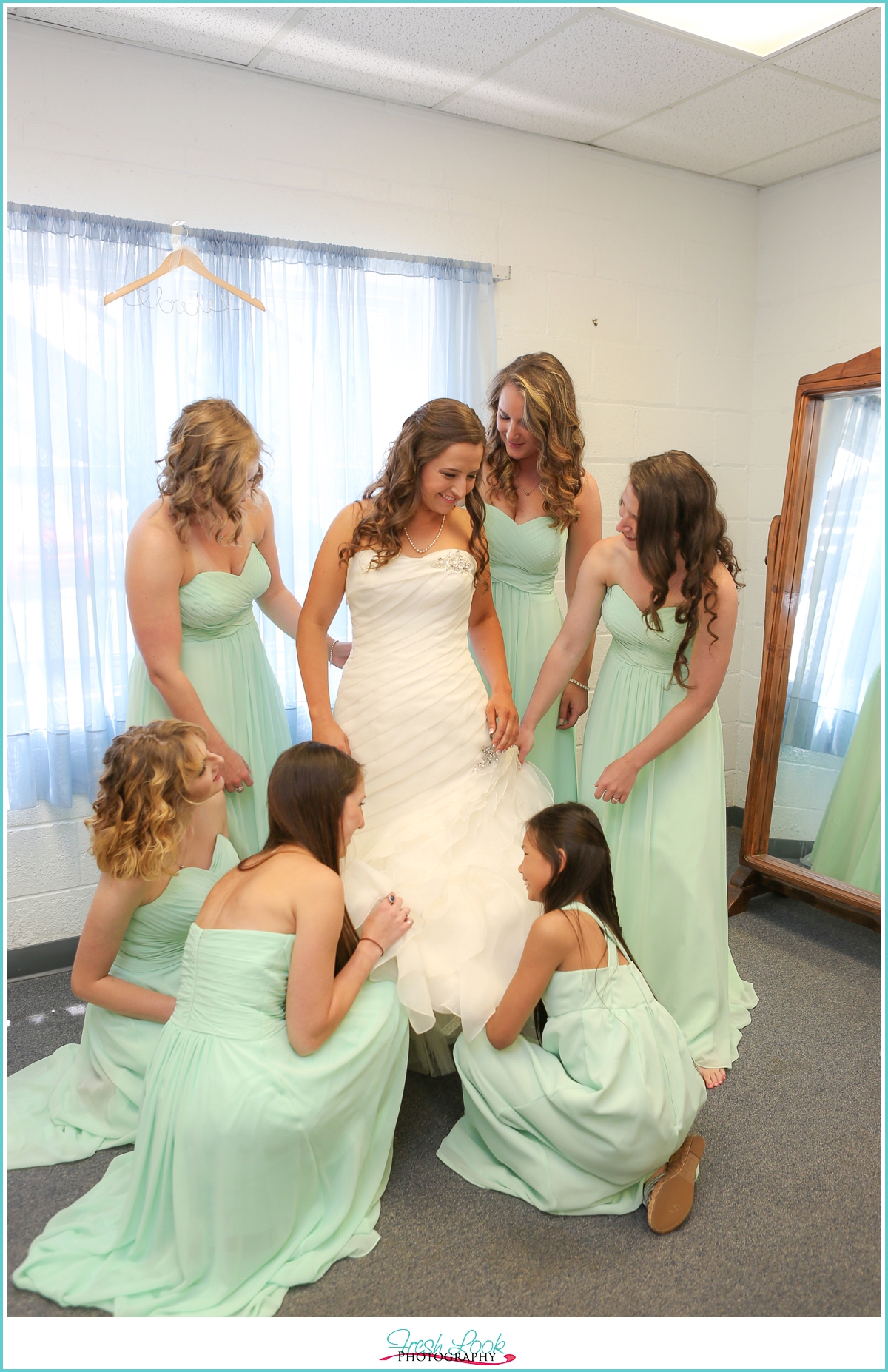 bridesmaids helping bride