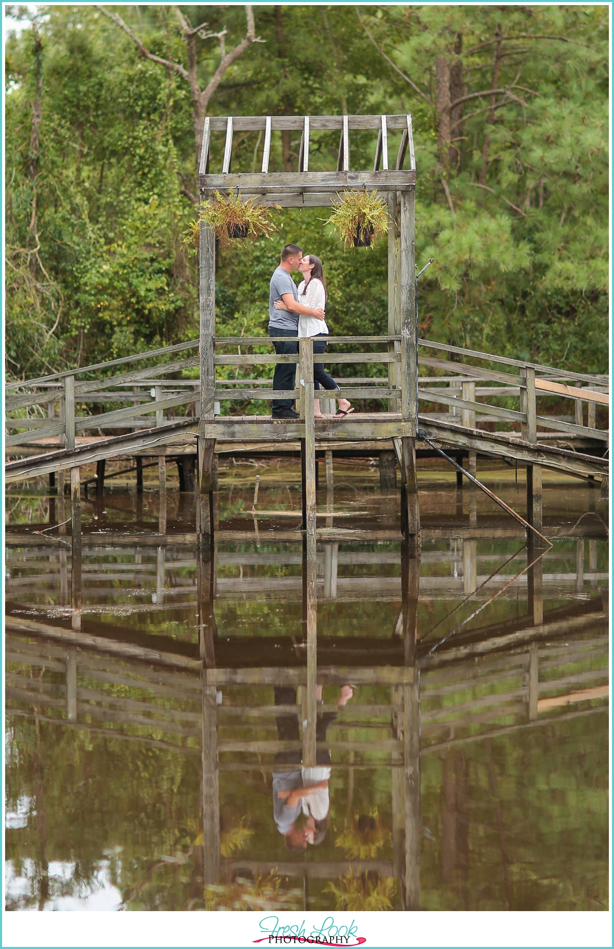 couple kissing on a bridge