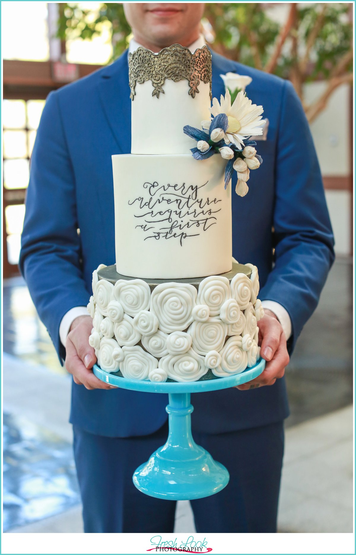 groom holding a cake