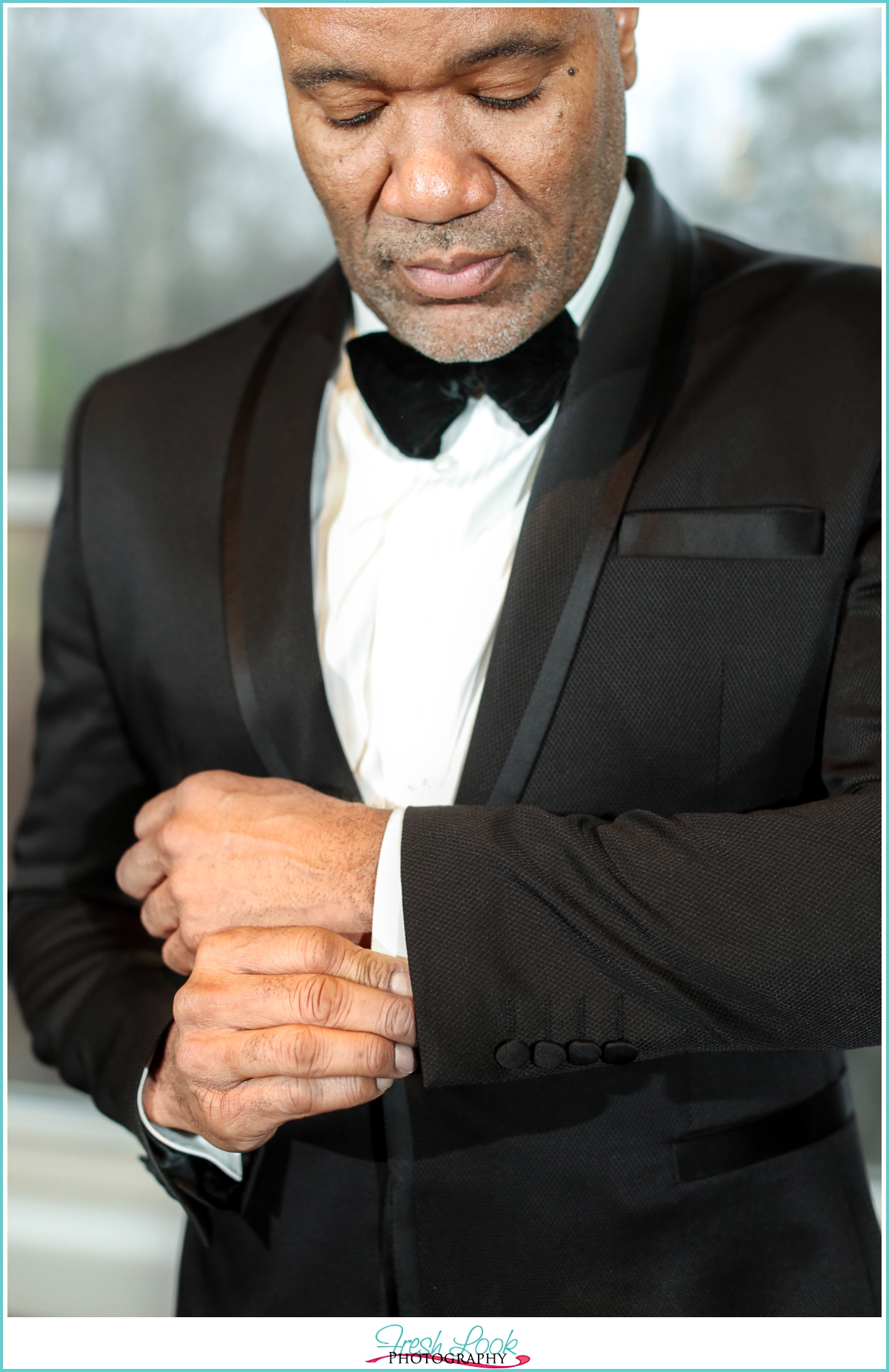 handsome groom in black tuxedo