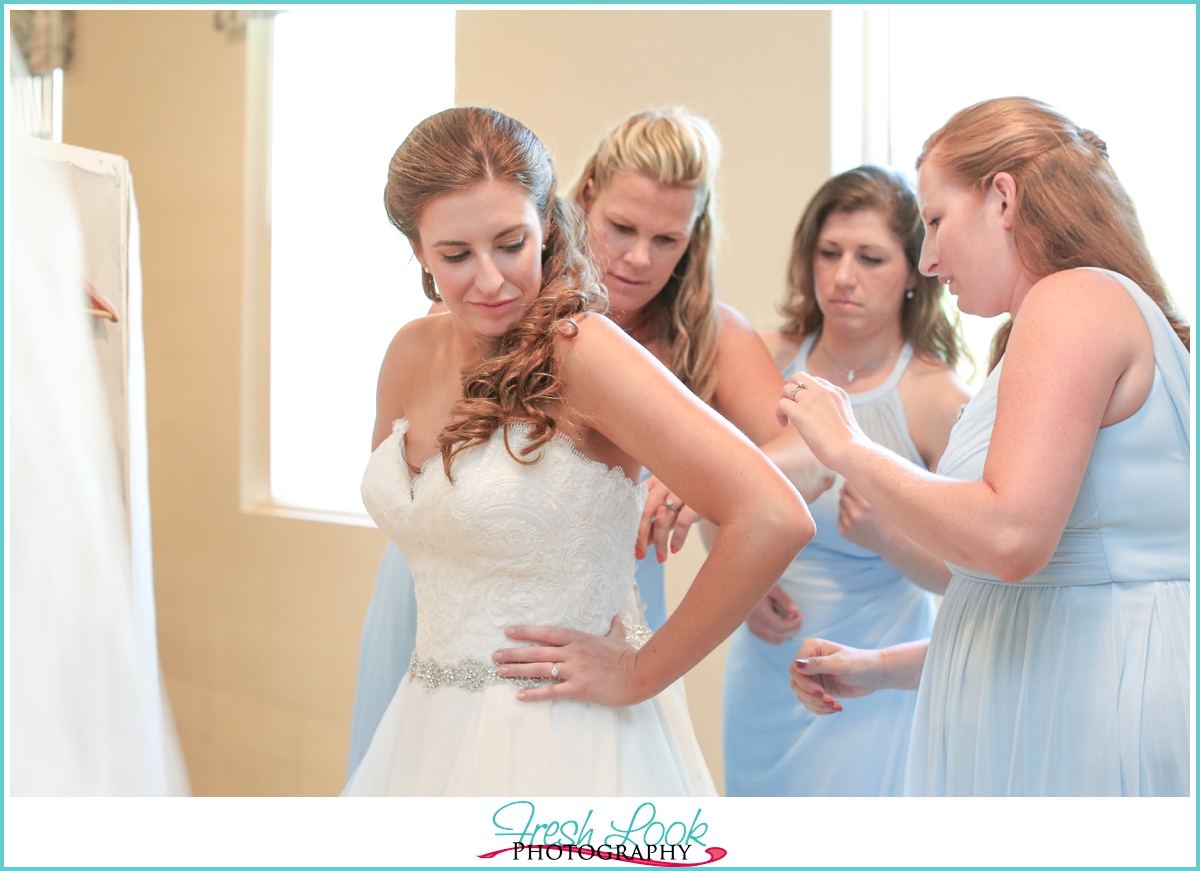 bride getting into wedding dress