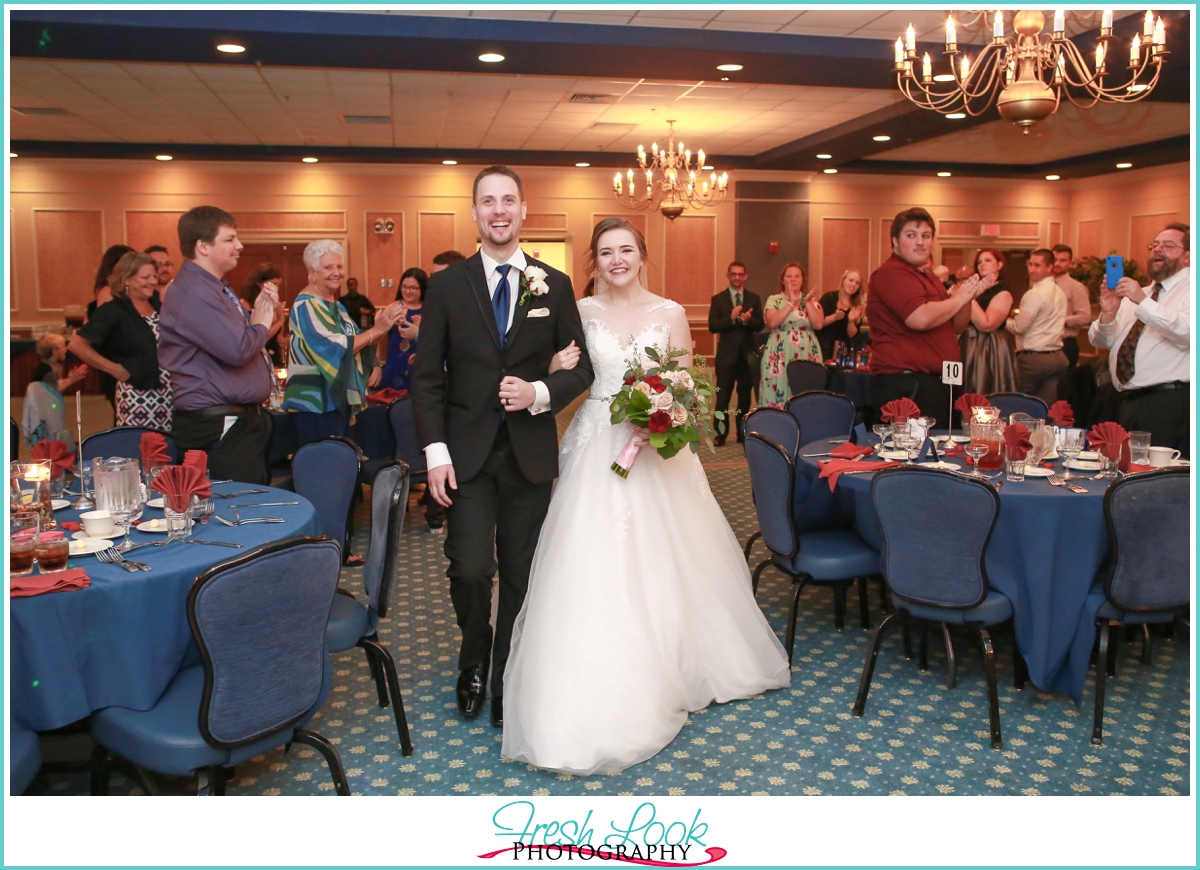 bride and groom walking into reception