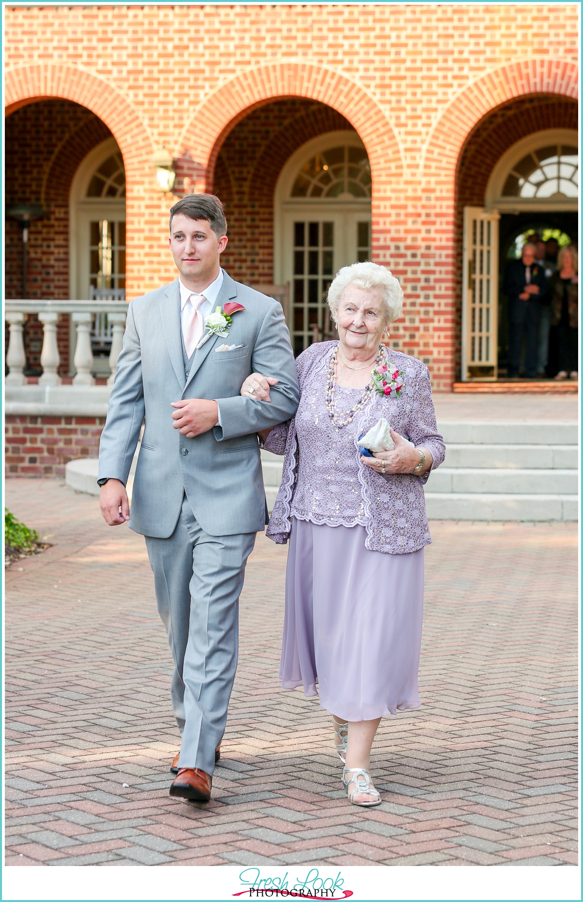Groom walking his mother down the aisle