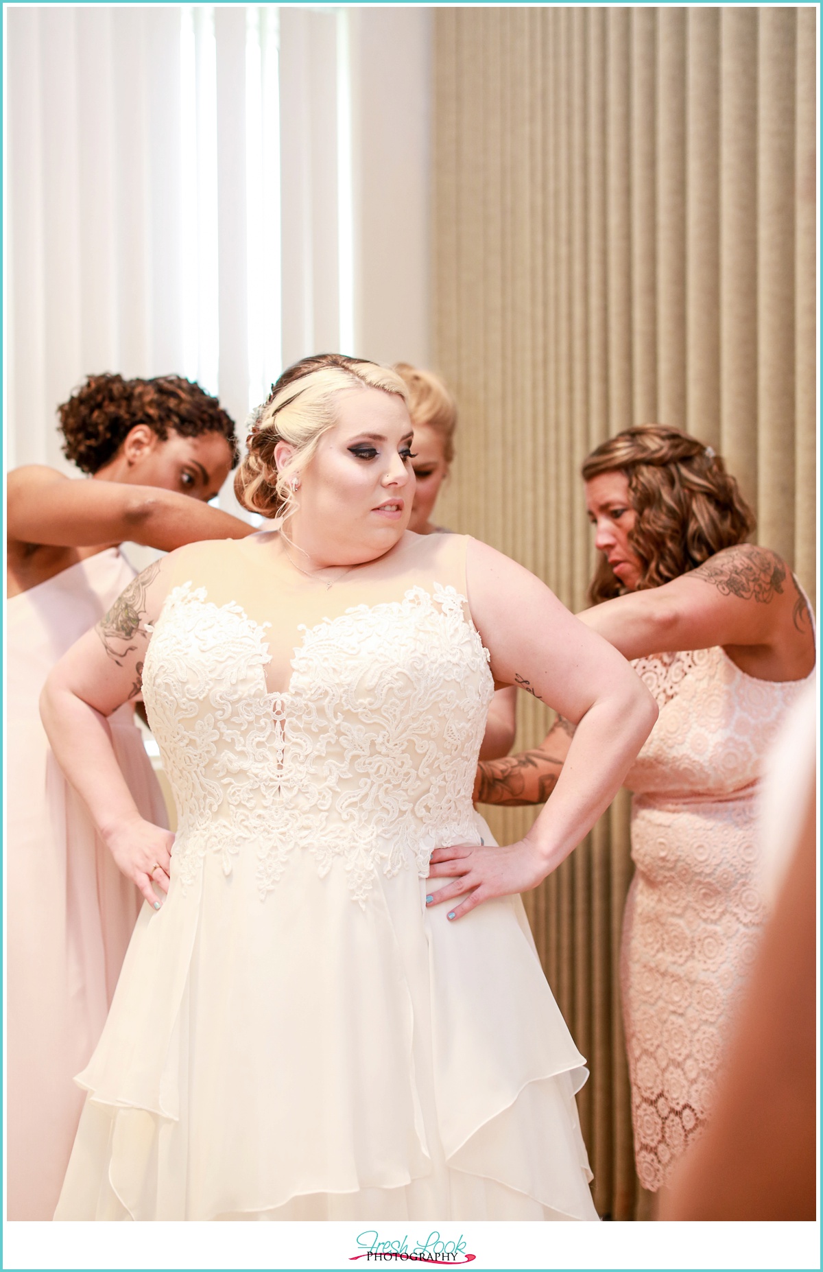 bride putting on wedding dress