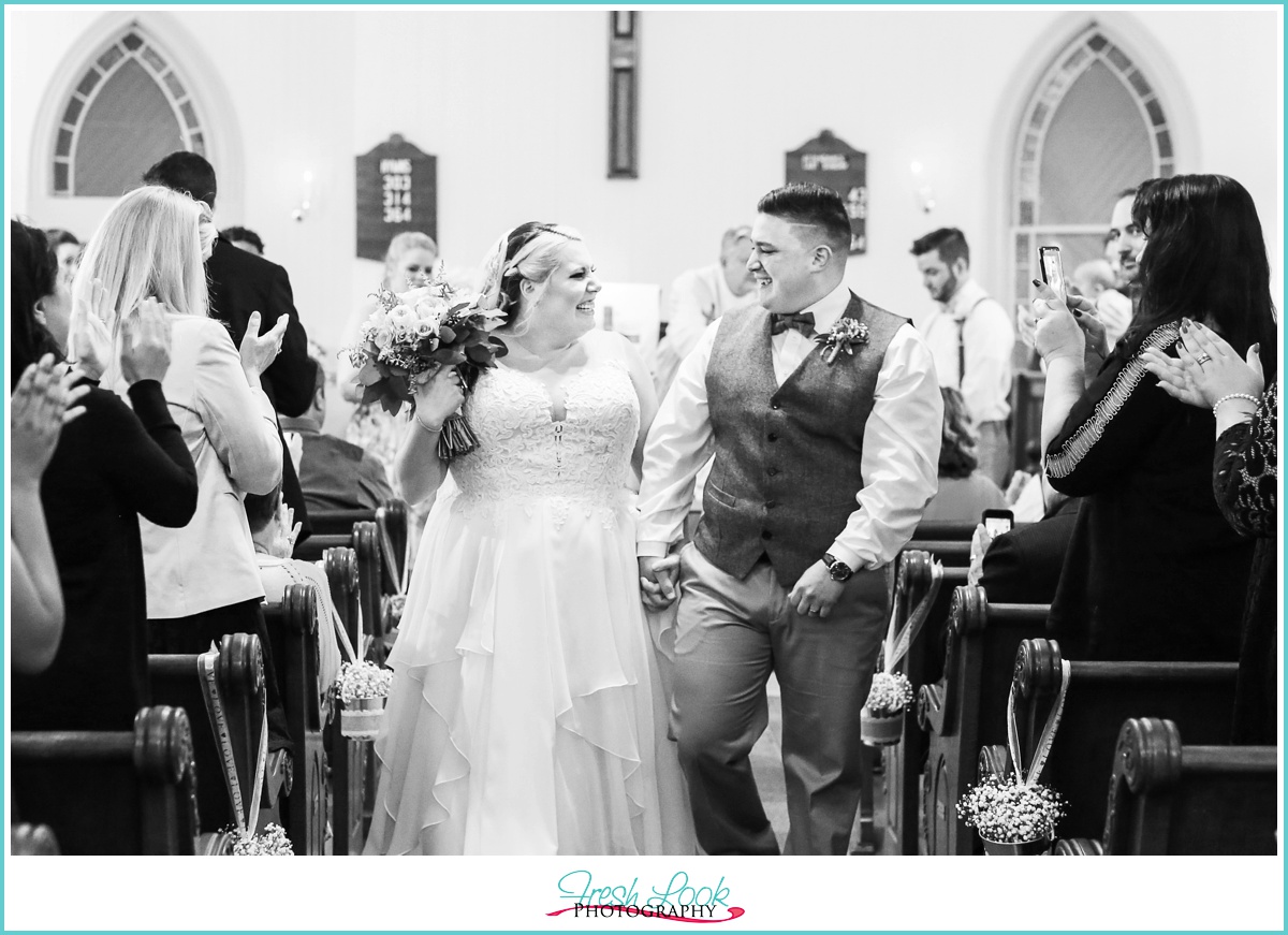 romantic bride and groom walking out of the church