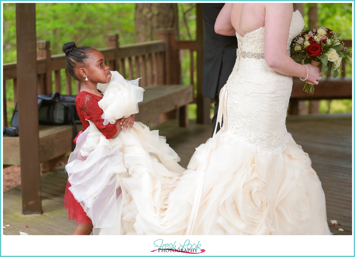 Flower girl holding brides train