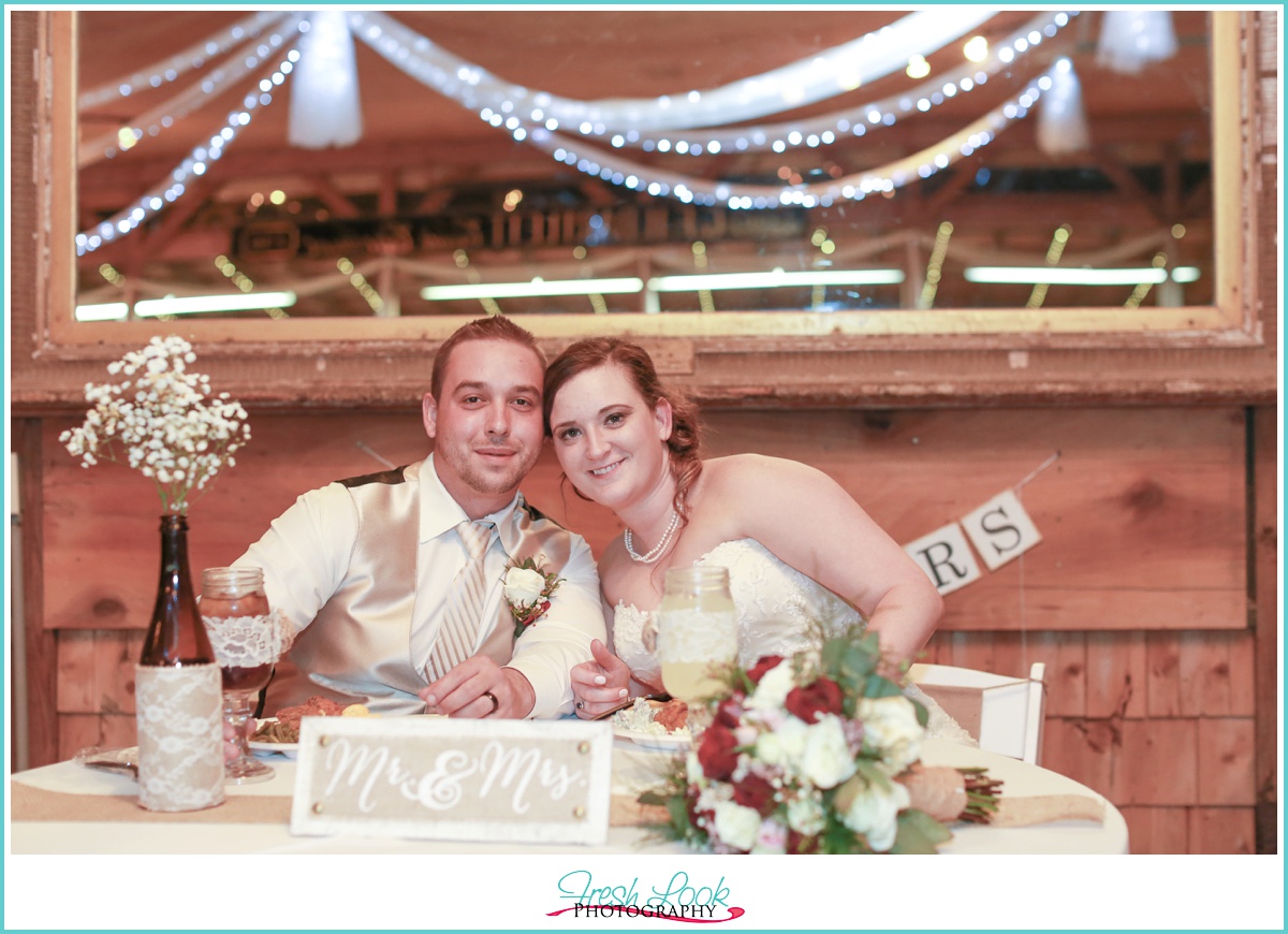 bride and groom sitting at sweetheart table