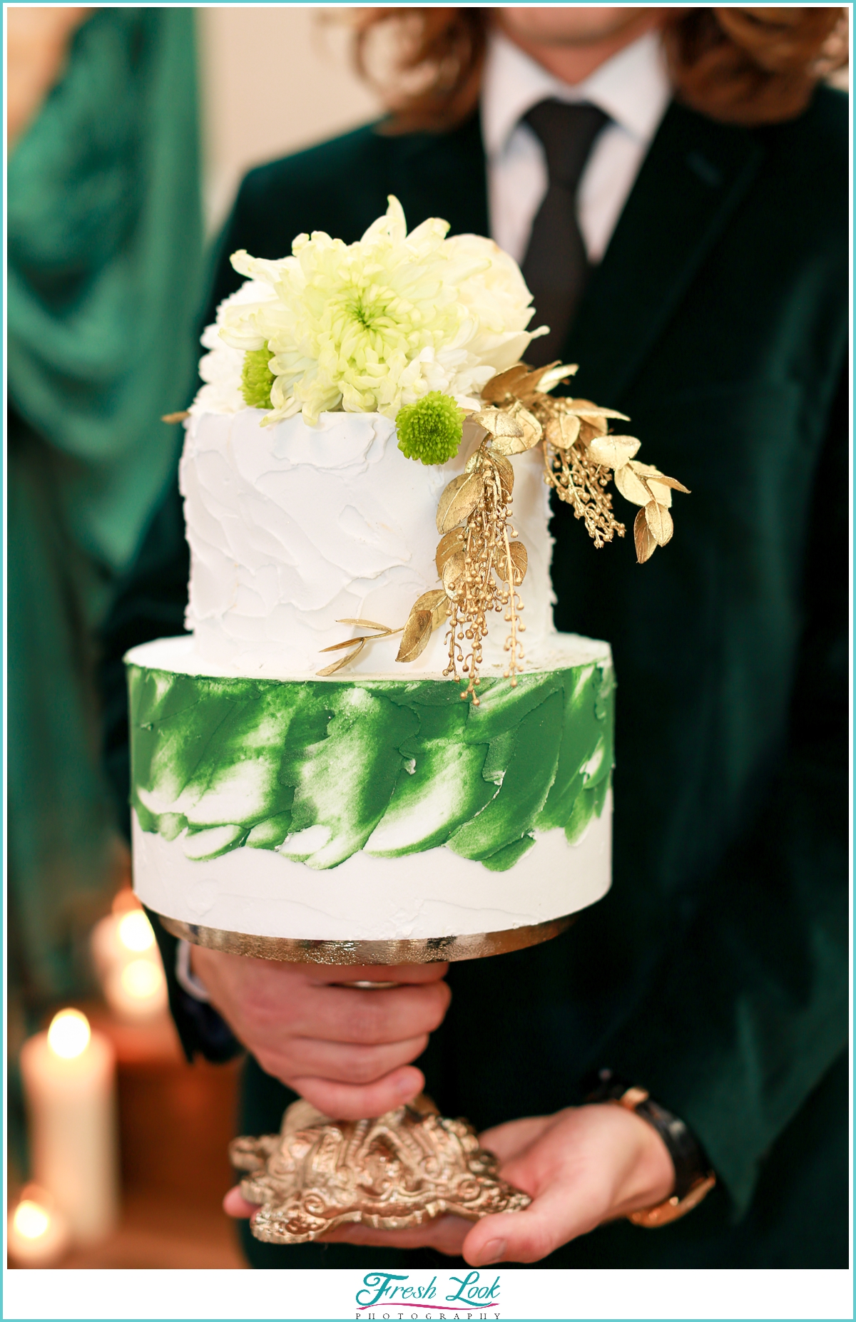 groom holding green and gold cake