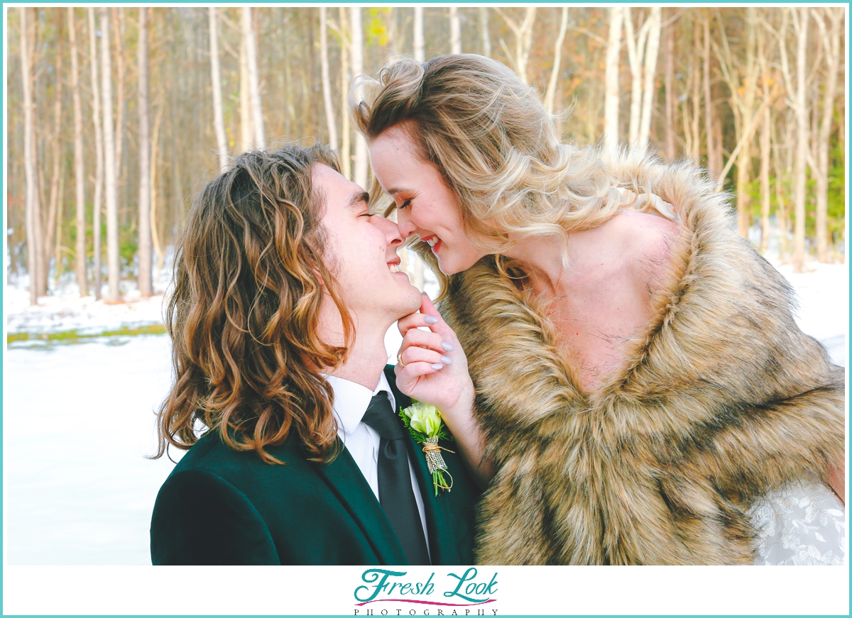 bride and groom kiss in the snow