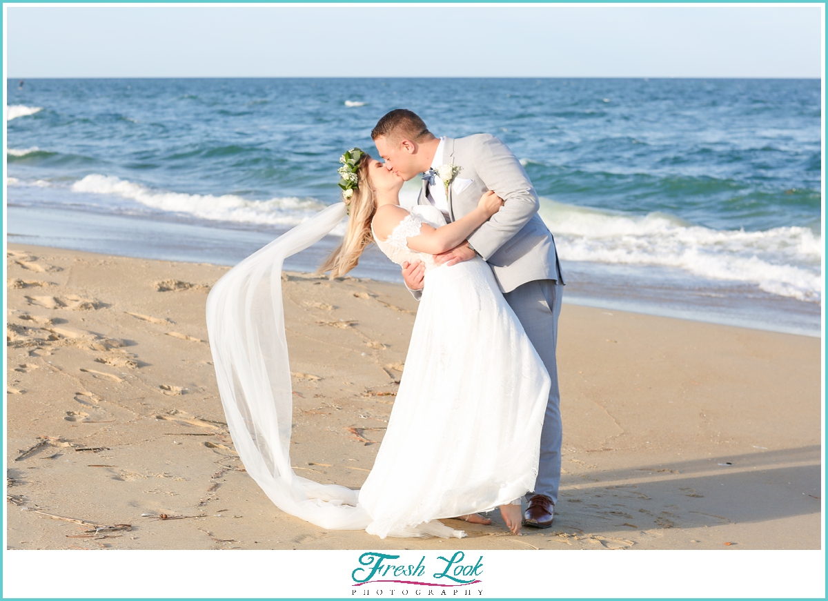 bride and groom kiss on the beach