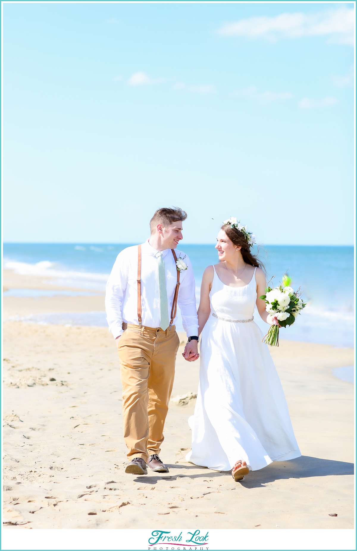 bride and groom walking on the beach