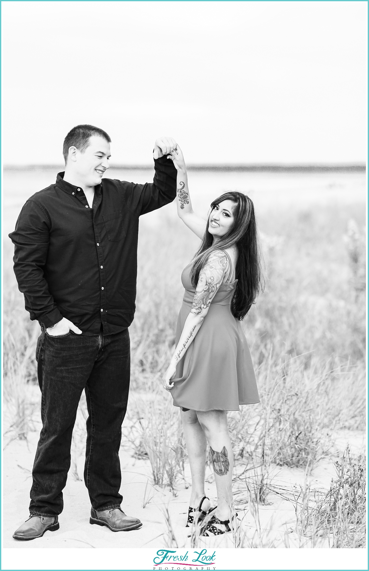 engaged couple dancing on the beach