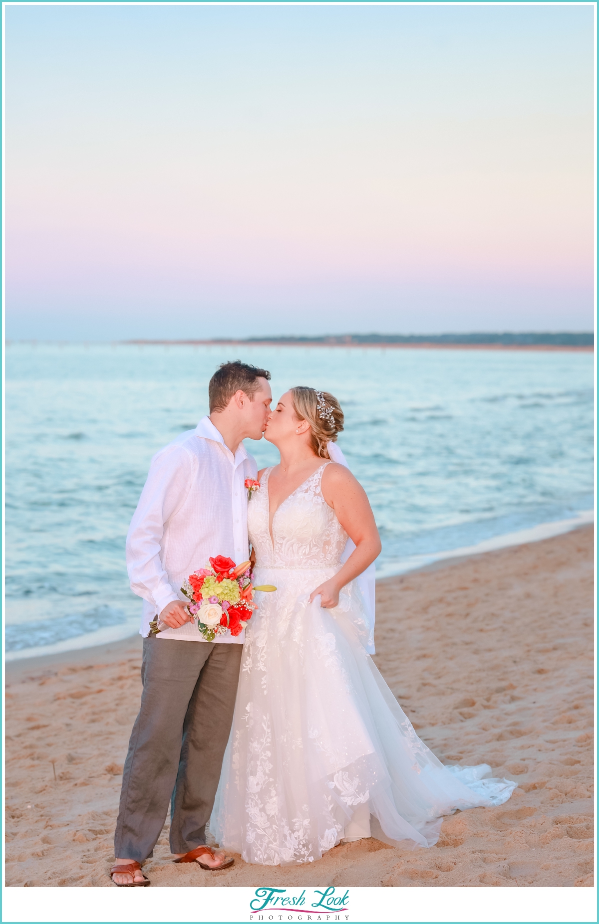 bride and groom kiss on the beach