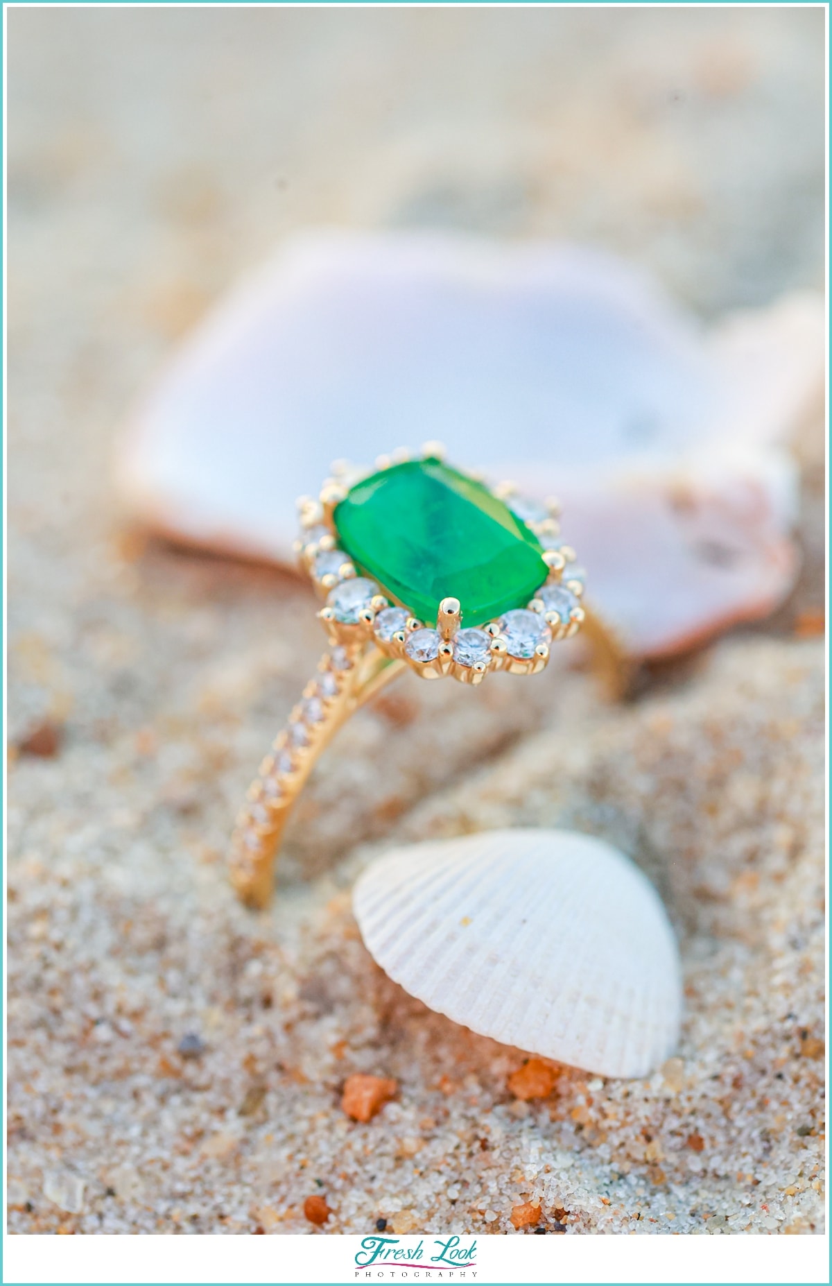 emerald engagement ring on the beach